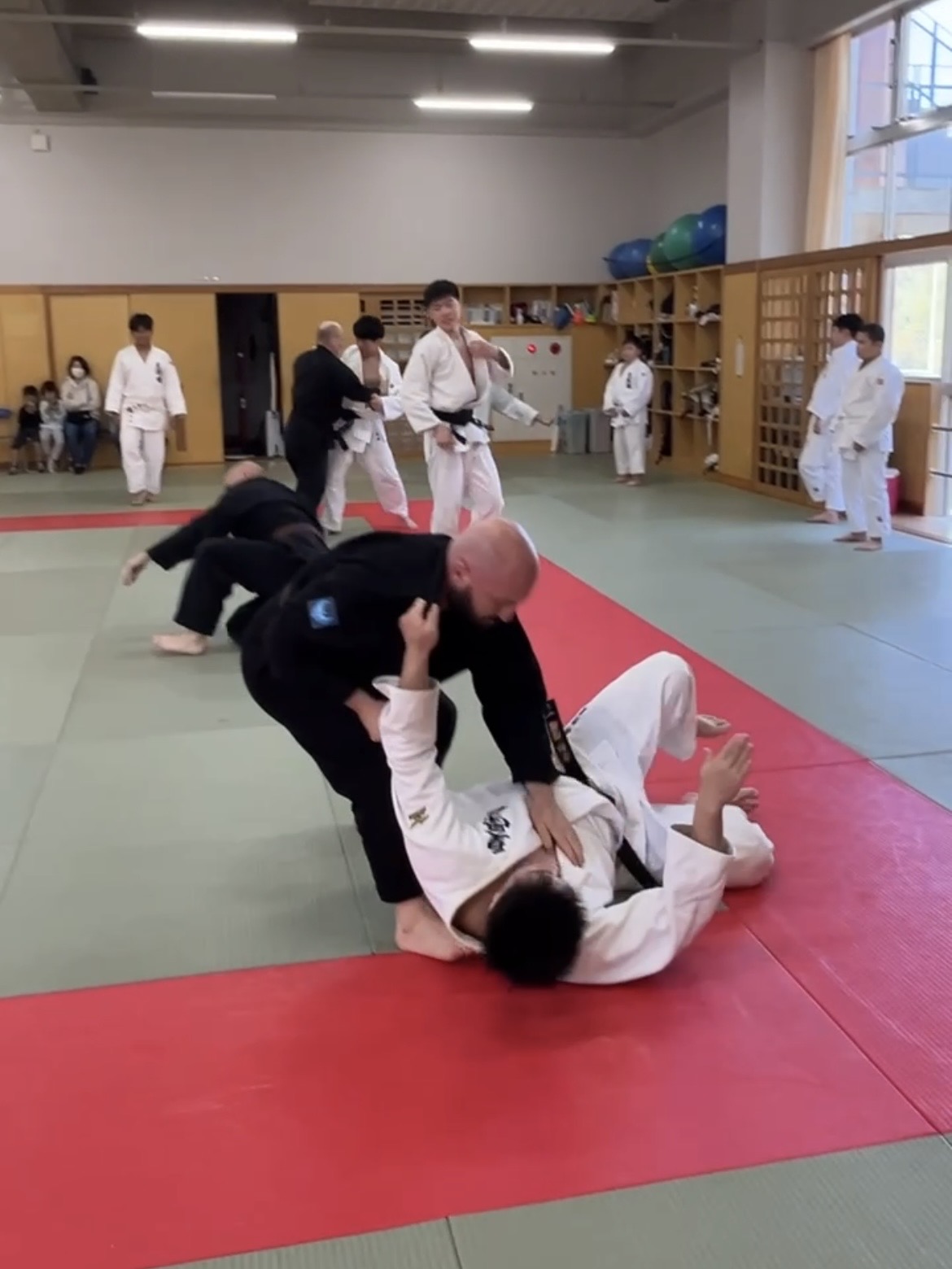 Judo practitioners in gis training throws and groundwork on tatami mats in a Japanese dojo