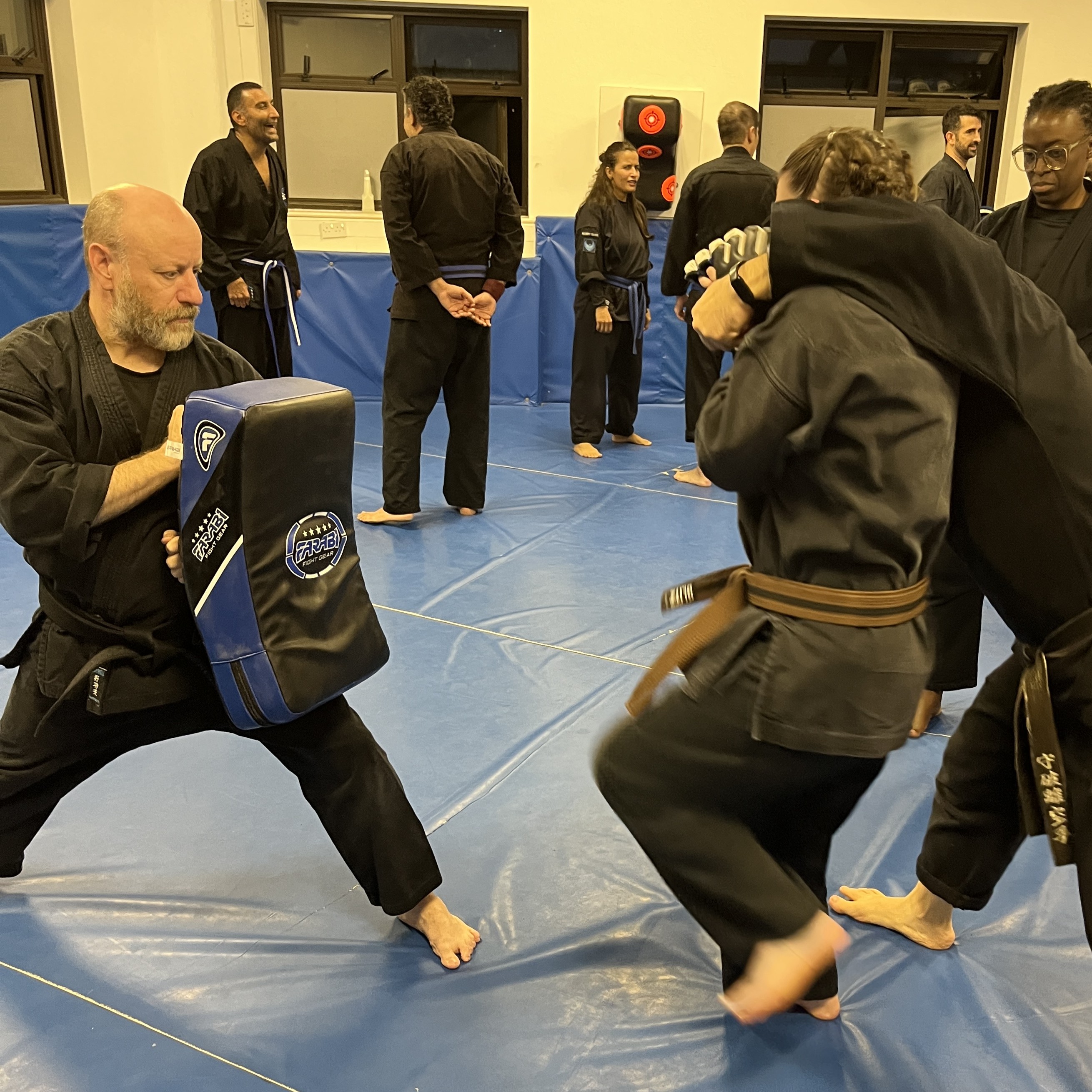 Brian Southon of Shuhari Self Defence Cippenham holding a kick shield in an adults karate class