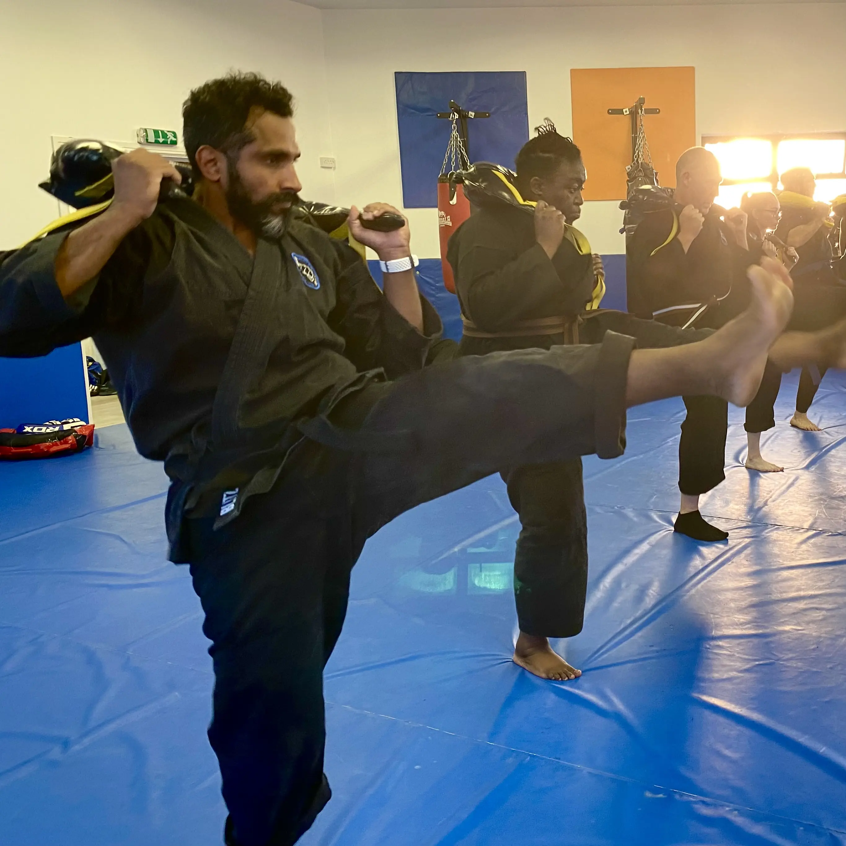 John Moses of Shuhari Self Defence Bracknell doing weighterd kicks with Bulgarian bag in an MMA lesson warmup