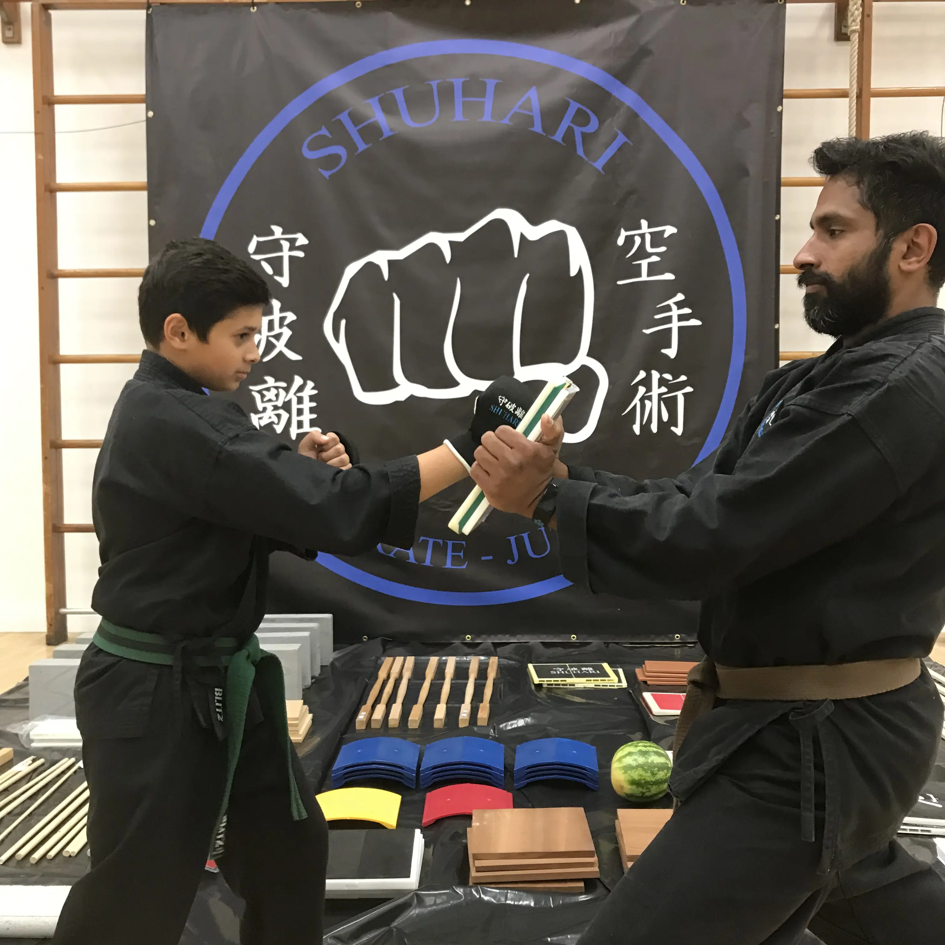 John Moses of Shuhari Self Defence Bracknell teaching board breaking to a karate student