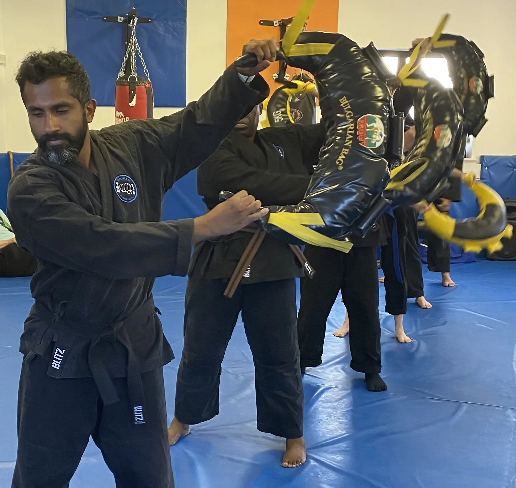 John Moses of Shuhari Self Defence Bracknell training with Bulgarian bag in martial arts lesson warmup