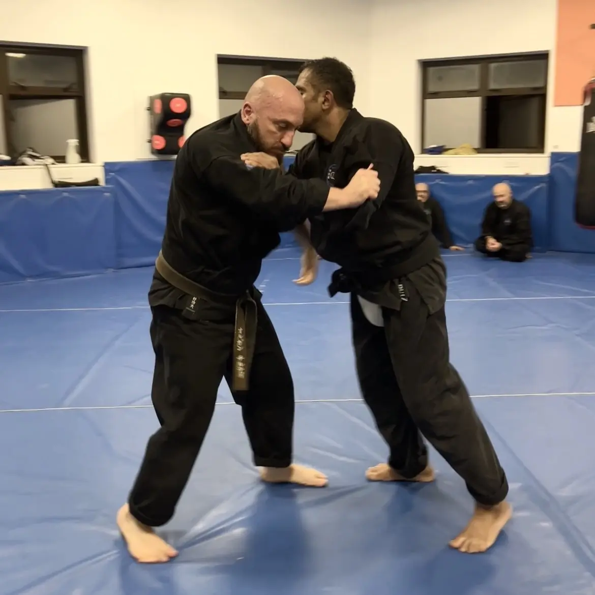 John Moses of Shuhari Self Defence Bracknell learning vertical grappling techniques from Olgun Tiltay in a martial arts class