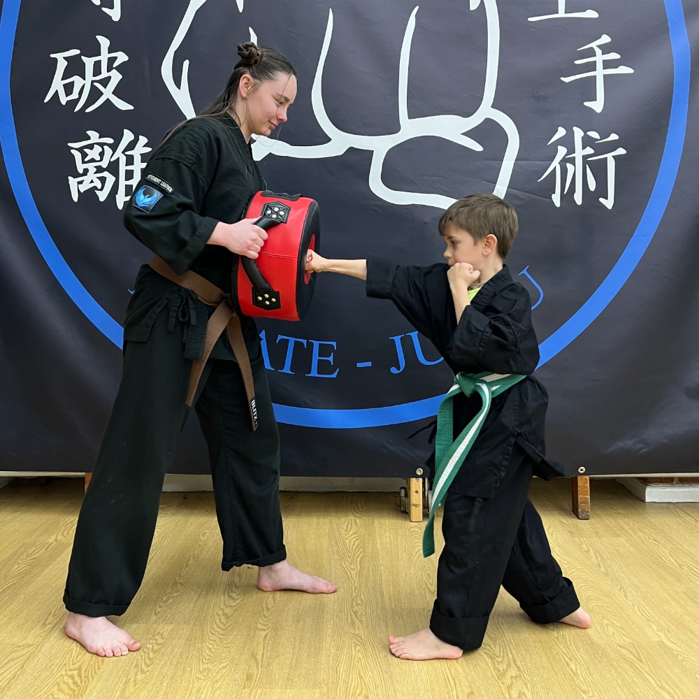Female martial arts instructor teaching children karate at Shuhari Self Defence Bracknell